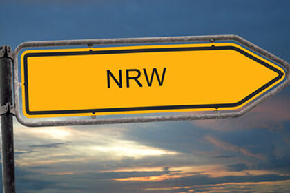 Ein gelber Wegweiser mit dem Wort NRW darauf
